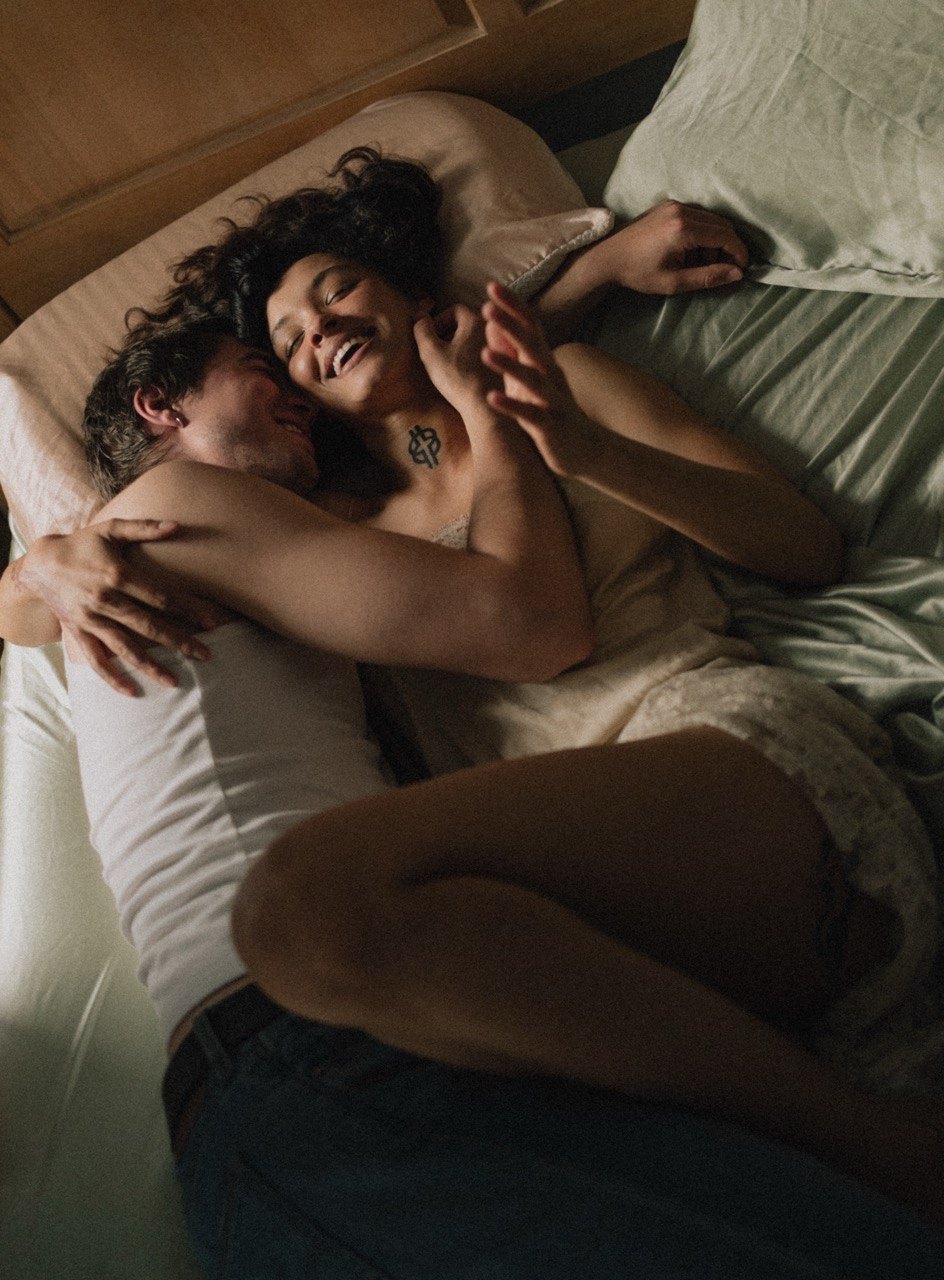 Couple in bed laughing together